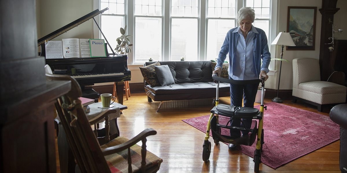Senior woman using walker in living room