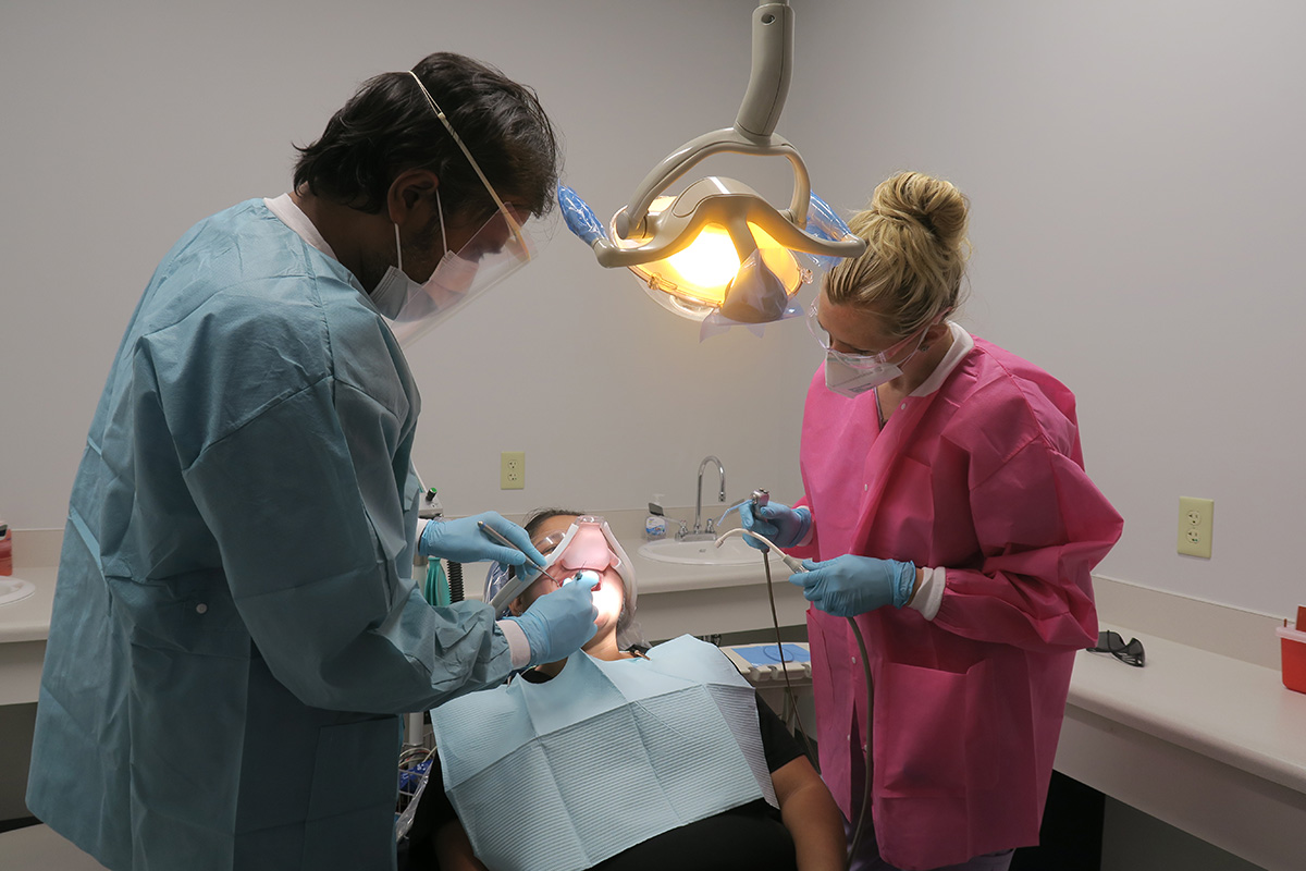 Dentist Michael McCracken DDS works on a patients mouth at the Spartanburg Community Dental Center while a dental assistant watches