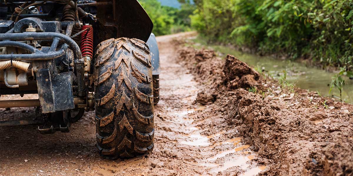 The front half of an ATV on a muddy road