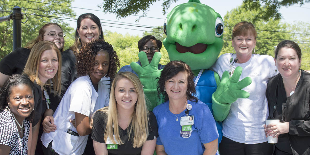 Shelldon the Turtle, SRHS's pediatric mascot, poses with staff