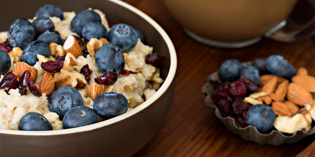 Closeup shot of a bowl of oatmeal with dried cranberries, blueberries and almonds on top