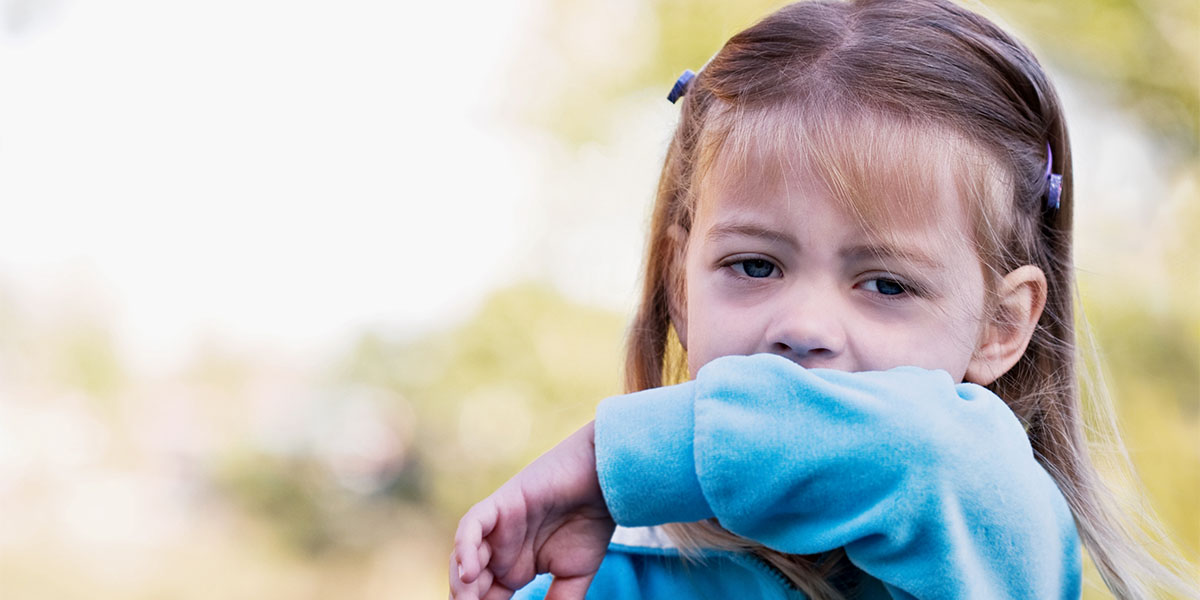 A little girl sneezing in to get elbow