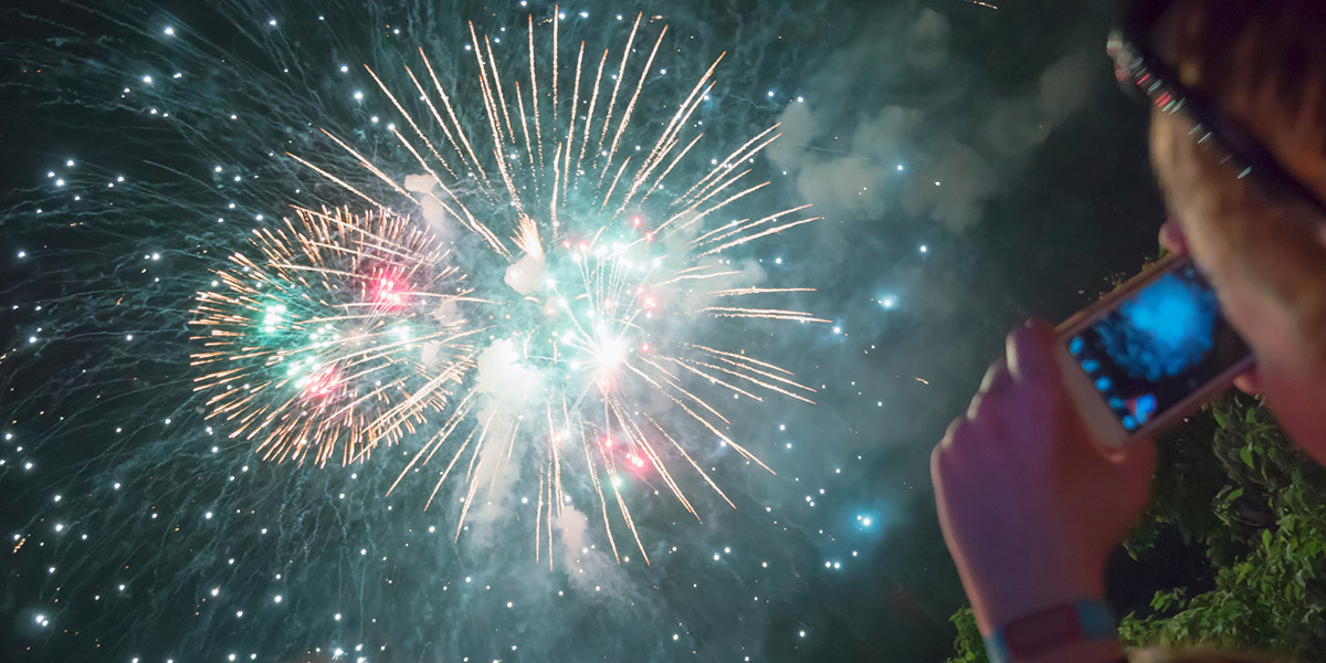 Woman photographing fireworks celebration