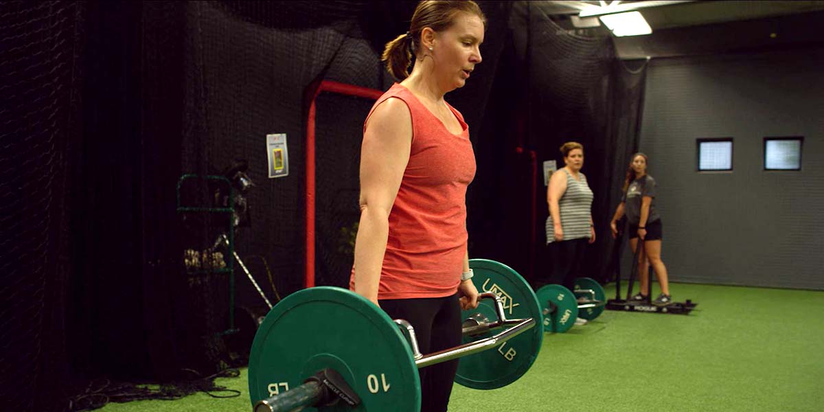 A woman in a gym deadlifting weights
