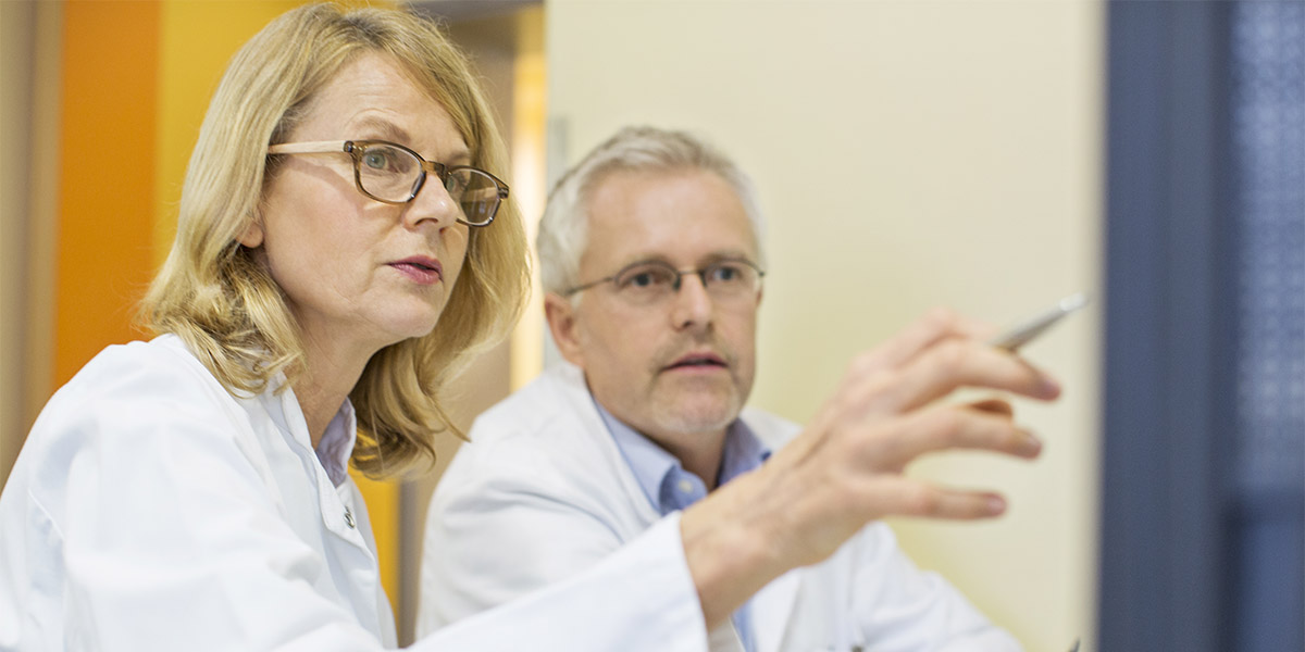 Doctors looking at computer on desk in hospital