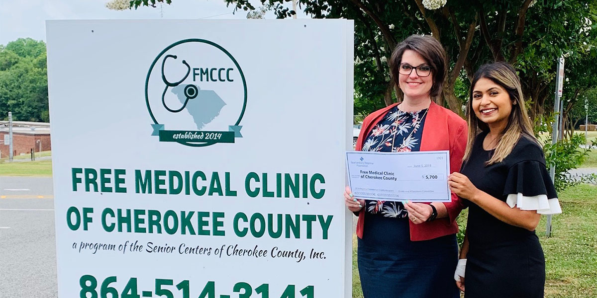 Heather Swayngim poses with a $5,700 grant check, awarded to the Free Medical Clinic of Cherokee County, where diabetes frequently adds to other health and social challenges