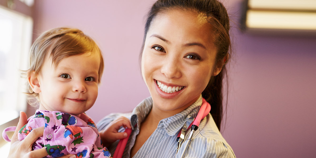 Young Girl Being Held By Female Pediatric Doctor