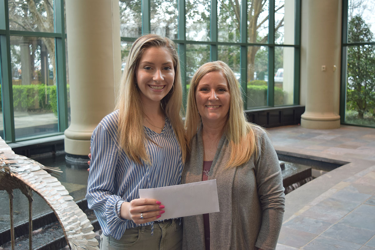 Ginger Dailey and her mother Tammy hold up a donation check the Spartanburg teen is contributing to the Gibbs Cancer Center & Research Institute.jpg