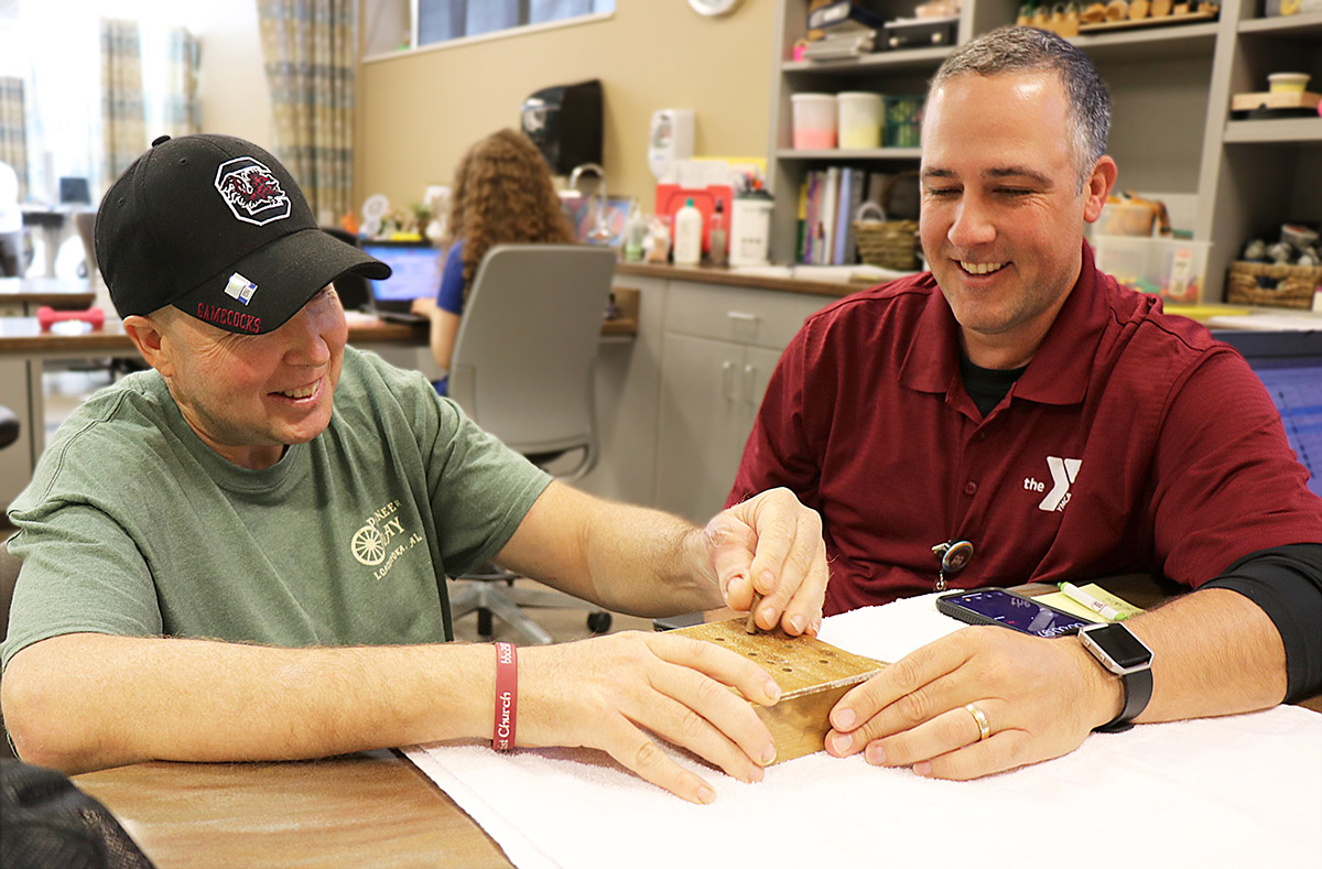 Occupational therapist Michael Maeder works with Glenn Allum, who recently received a toe to thumb transpant surgery after he lost his thumb in an accident with a wood splitter.jpg