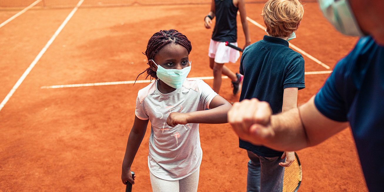 Kids elbow bumping their tennis instructor