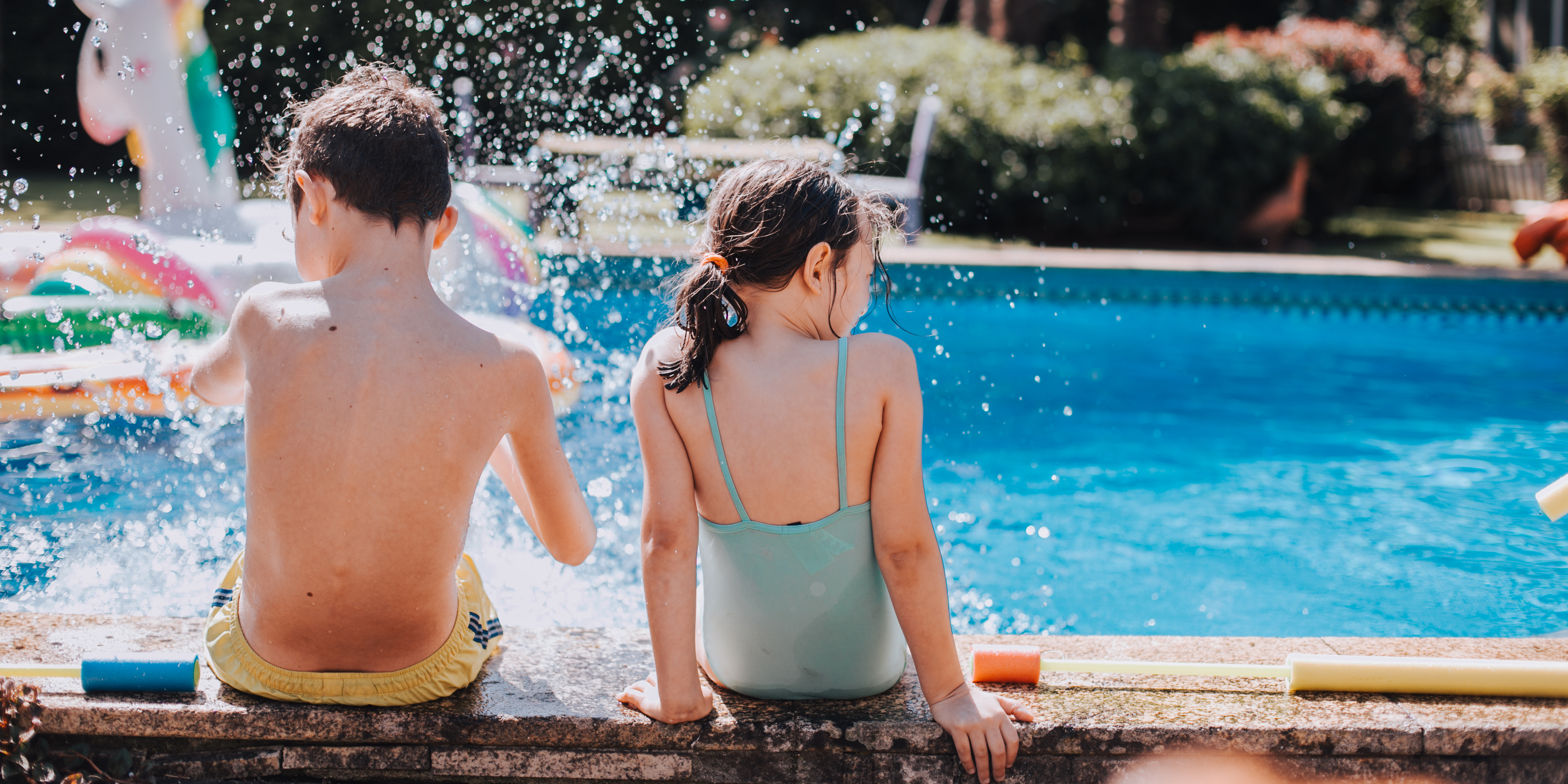 kids at edge of pool, kicking and splashing