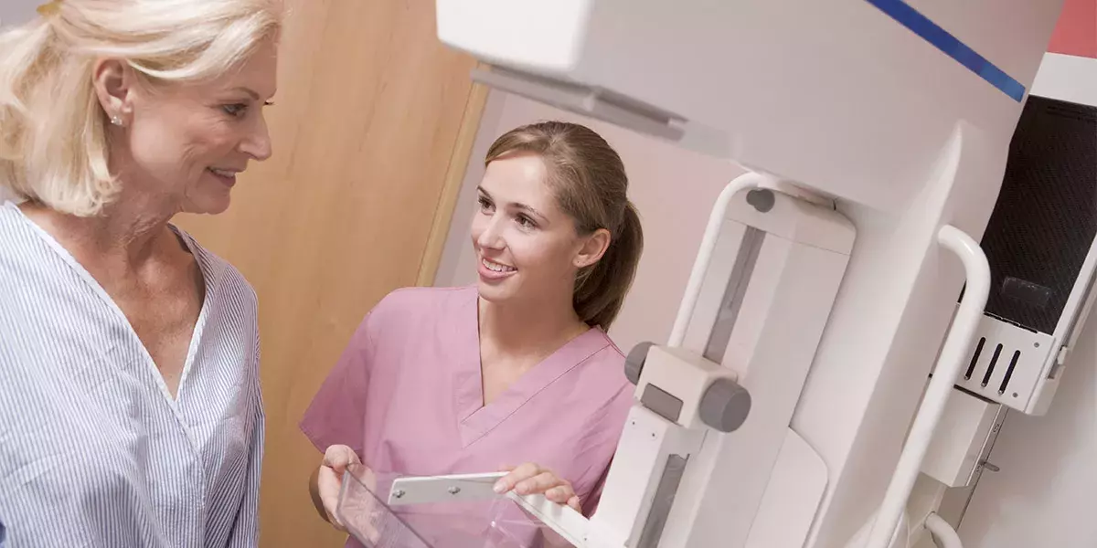 Nurse Assisting Patient About To Have A Mammogram